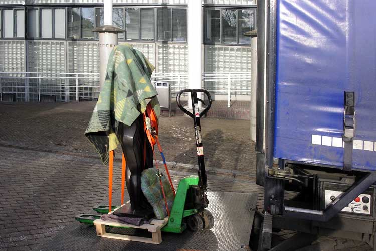 Het transport en plaatsing van een bronzen beeld van Han van Wetering in Apeldoorn.