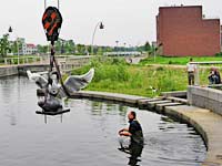 plaatsing van een bronzen beeld van Evert den Hartog in een waterpartij